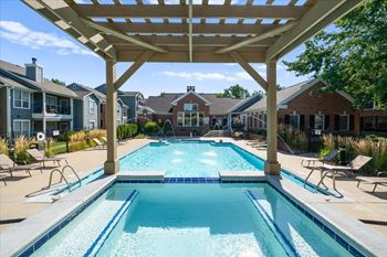 A large swimming pool under a wooden pergola. at Somerset Oaks Apartment Homes, Kansas